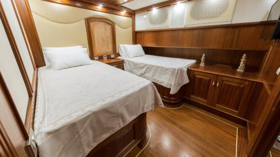 Comfortable twin cabin with two single beds and elegant decor on the Halcon Del Mar.